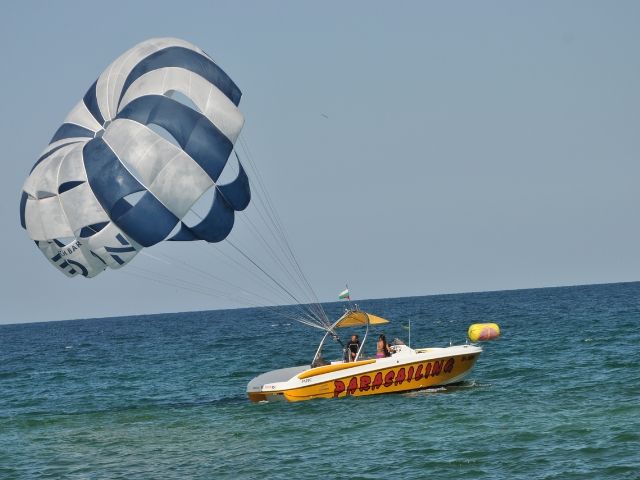 лодка в морето дърпа парашут за парасейлинг - снимка