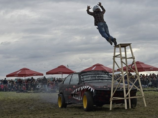 мъж скача над автомобил - каскада в Луда надпревара - снимка
