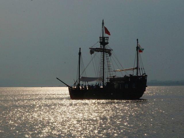 кораб плава в морето по залез слънце - снимка