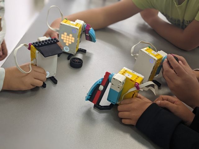няколко деца играят с лего роботи - снимка