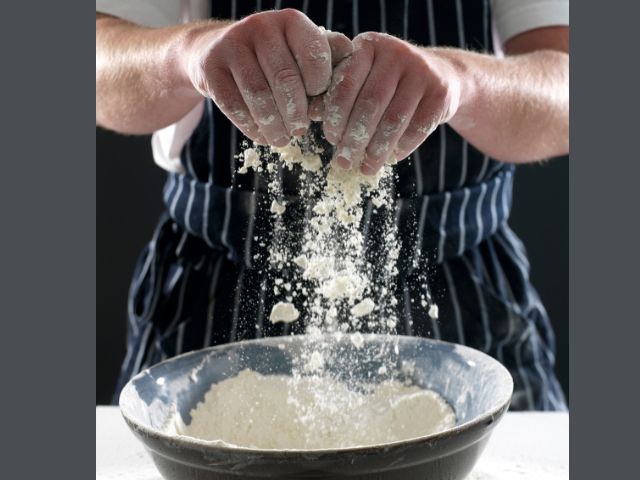 майстор пекар работи с брашно за приготвяне на хляб -снимка