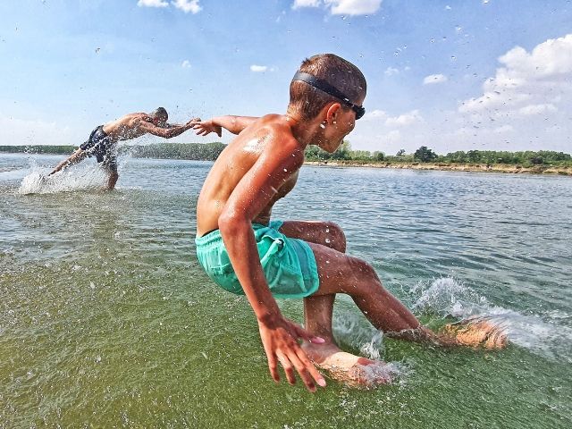 дете се хвърля във водата на река Дунав - снимка