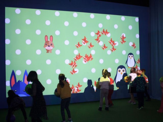 деца играят на интерактивна игра в зала - снимка