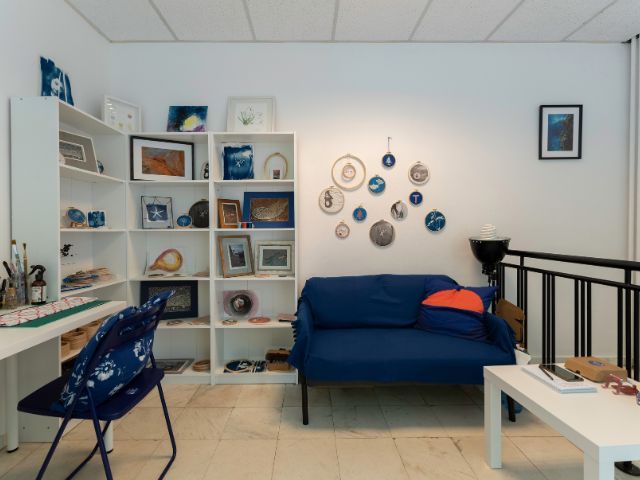 арт студио със син диван и бели стени