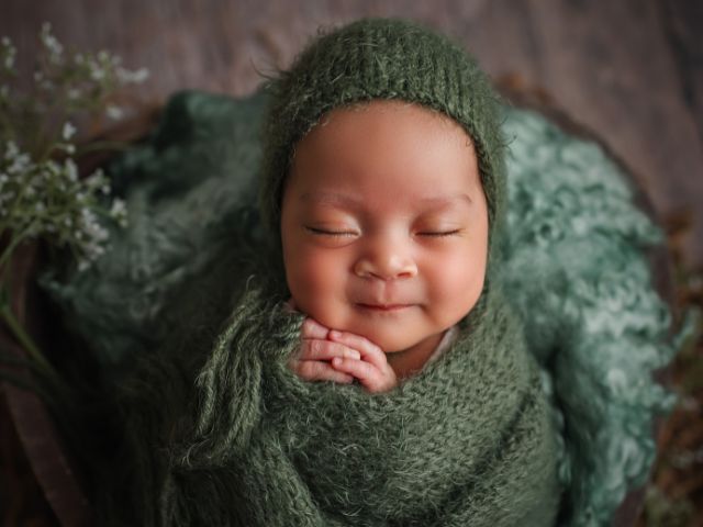 спящо бебе, завито в зелен шал