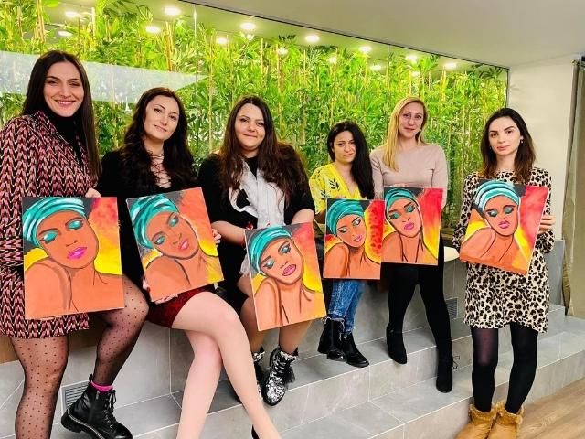 група жени позират с рисунки на жени
