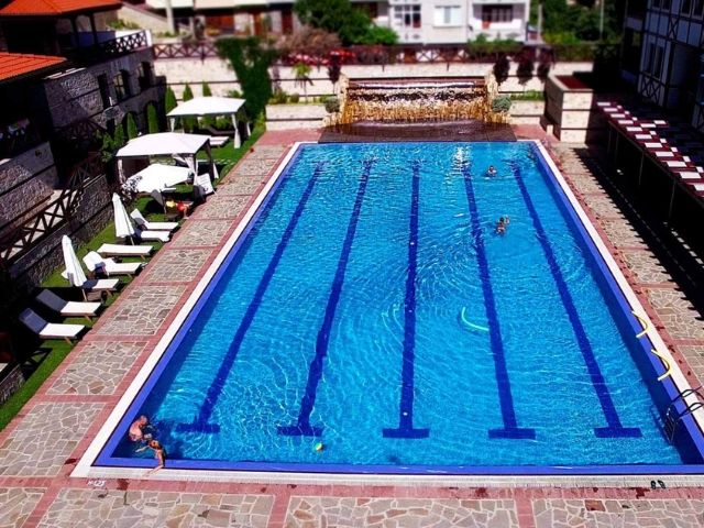 плувен басейн с шезлонги отстрани - снимка