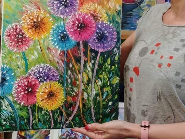 Жена държи картина на цветя