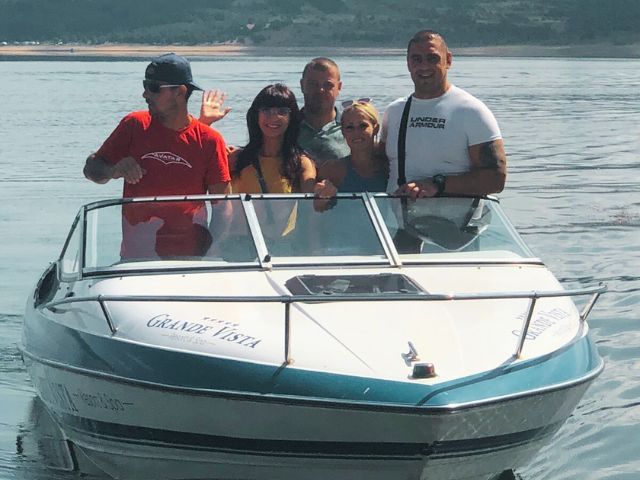 група от трима мъже и две жени на борда на моторна яхта